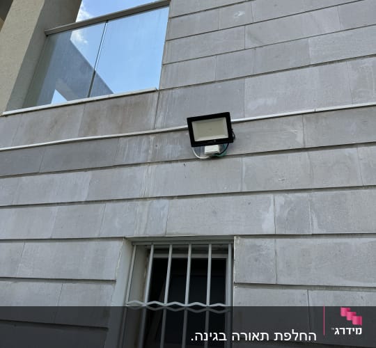 פנס חיצוני מותקן על קיר בטון אפור
